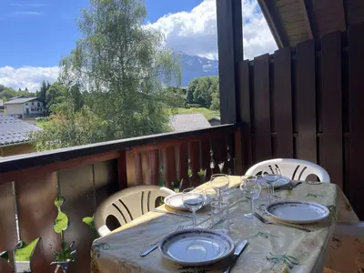 a table with plates and wine glasses on a balcony at Duplex lumineux 3 pièces, 7 pers, 3 balcons, proche pistes et commerces, parking, ski bus - FR-1-572-72 in Arâches-la-Frasse