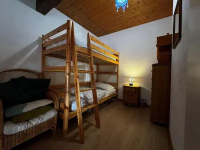 a bedroom with two bunk beds and a couch at Duplex 6 pers sur pistes débutants avec parking - Les Carroz d'Arâches - FR-1-572-74 in Arâches-la-Frasse