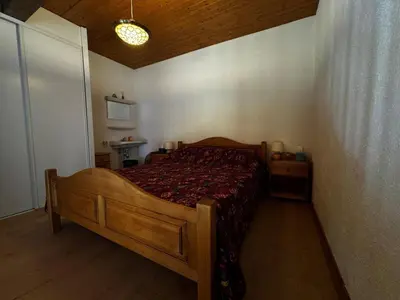 a bedroom with a wooden bed in a room at Duplex 6 pers sur pistes débutants avec parking - Les Carroz d'Arâches - FR-1-572-74 in Arâches-la-Frasse
