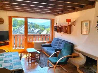 a living room with a blue couch and a balcony at Duplex moderne 3 pièces proche des pistes, 8 pers. - FR-1-572-71 in Arâches-la-Frasse