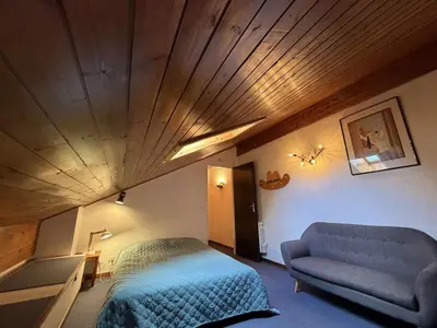 a bedroom with a bed and a couch in a room at Duplex moderne 3 pièces proche des pistes, 8 pers. - FR-1-572-71 in Arâches-la-Frasse