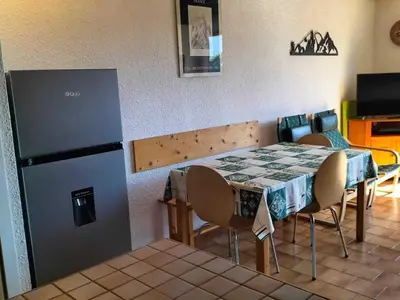 a dining room with a table and a refrigerator at Duplex moderne 3 pièces proche des pistes, 8 pers. - FR-1-572-71 in Arâches-la-Frasse