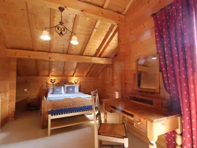 a bedroom in a log cabin with a bed and a desk at Chalet typique 10 pers, Arâches-la-Frasse - FR-1-572-27 in Arâches-la-Frasse