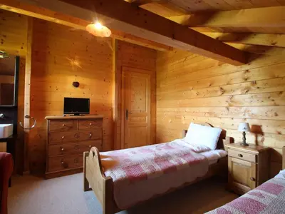 a bedroom in a log cabin with a bed and a tv at Chalet typique 10 pers, Arâches-la-Frasse - FR-1-572-27 in Arâches-la-Frasse