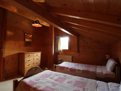 a bedroom with two beds in a log cabin at Chalet typique 10 pers, Arâches-la-Frasse - FR-1-572-27 in Arâches-la-Frasse