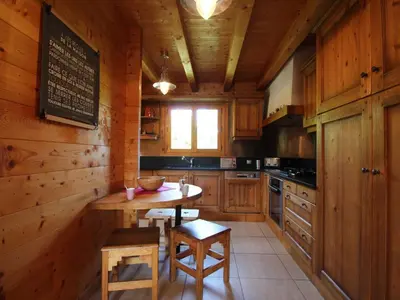 a kitchen with wooden walls and a table and chairs at Chalet typique 10 pers, Arâches-la-Frasse - FR-1-572-27 in Arâches-la-Frasse