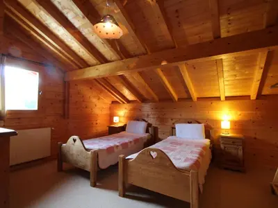 a bedroom with two beds in a log cabin at Chalet typique 10 pers, Arâches-la-Frasse - FR-1-572-27 in Arâches-la-Frasse