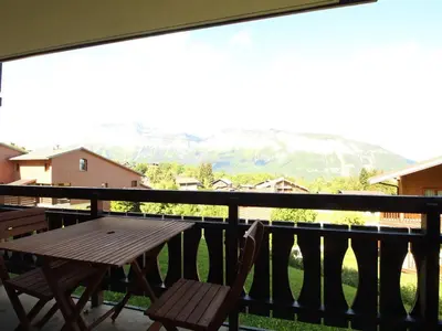 a table and chairs on a balcony with a view of a mountain at Appartement 2 pièces 5 pers, pied des pistes, garage privé, proche village et commerces - FR-1-572-57 in Arâches-la-Frasse