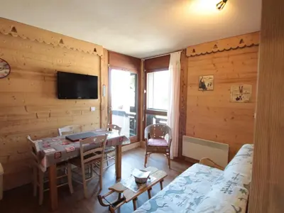 a room with a table and a bed and a television at Appartement cosy 4 pers au pied des pistes avec parking, balcon, lave-vaisselle et services additionnels - FR-1-572-87 in Arâches-la-Frasse