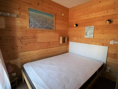 a bedroom with a bed in a wooden room at Appartement cosy 4 pers au pied des pistes avec parking, balcon, lave-vaisselle et services additionnels - FR-1-572-87 in Arâches-la-Frasse