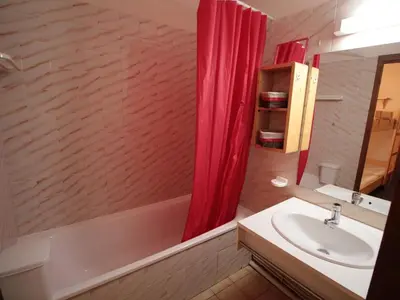 a bathroom with a sink and a red shower curtain at Appartement cosy 4 pers au pied des pistes avec parking, balcon, lave-vaisselle et services additionnels - FR-1-572-87 in Arâches-la-Frasse