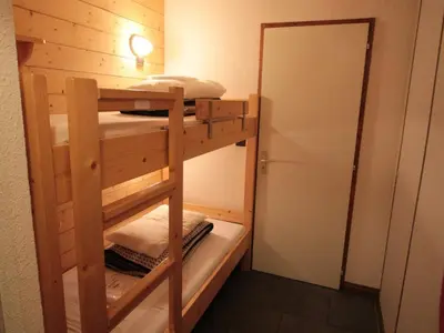 a bunk bed room with two bunk beds and a mirror at Appartement cosy 4 pers au pied des pistes avec parking, balcon, lave-vaisselle et services additionnels - FR-1-572-87 in Arâches-la-Frasse