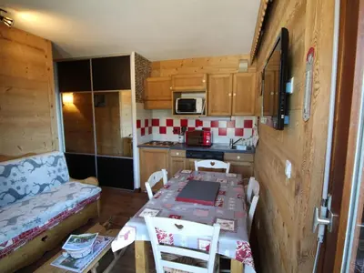 a small kitchen with a table and a dining room at Appartement cosy 4 pers au pied des pistes avec parking, balcon, lave-vaisselle et services additionnels - FR-1-572-87 in Arâches-la-Frasse