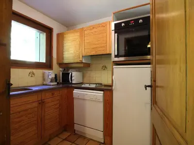 a kitchen with wooden cabinets and a white refrigerator at Appartement cosy 5 pers., pied des pistes, balcon est, proche commerces, parking & services - FR-1-572-94 in Arâches-la-Frasse