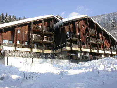 a building with snow on the ground in front of it at Appartement cosy 5 pers., pied des pistes, balcon est, proche commerces, parking & services - FR-1-572-94 in Arâches-la-Frasse