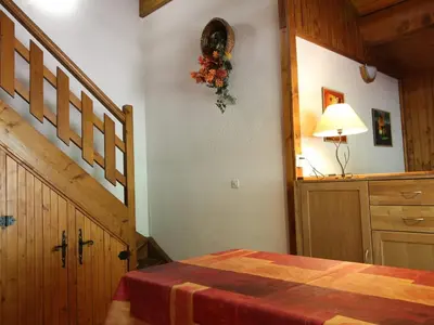 a bedroom with a staircase and a bed with a table at Appartement cosy 5 pers., pied des pistes, balcon est, proche commerces, parking & services - FR-1-572-94 in Arâches-la-Frasse
