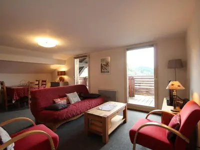 a living room with a red couch and a table at 3 Pièces 6 Pers, Proche Pistes & Centre, Balcon Sud, Parking, Non-Fumeur - FR-1-572-158 in Arâches-la-Frasse
