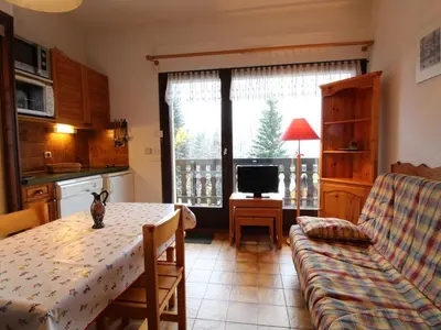 a living room with a table and a couch at Studio pour 4 personnes avec balcon et équipements, au pied des pistes et à 550m du village - FR-1-572-157 in Arâches-la-Frasse