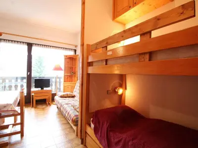a bedroom with a bunk bed and a living room at Studio pour 4 personnes avec balcon et équipements, au pied des pistes et à 550m du village - FR-1-572-157 in Arâches-la-Frasse
