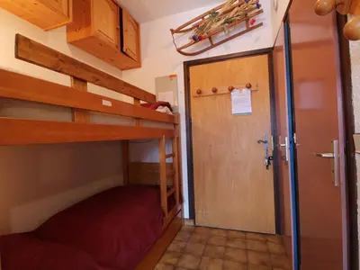 a bedroom with two bunk beds and a door at Studio pour 4 personnes avec balcon et équipements, au pied des pistes et à 550m du village - FR-1-572-157 in Arâches-la-Frasse
