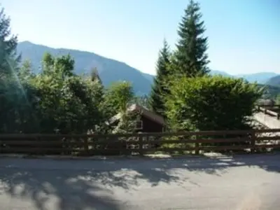 a fence and a house with mountains in the background at Studio 4 pers. avec lave-linge, balcon et accès direct aux pistes - Proche centre des Carroz - FR-1-572-176 in Arâches-la-Frasse
