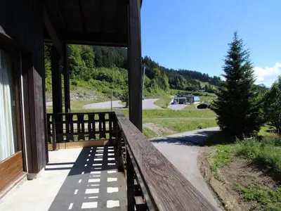 a porch of a house with a fence and a tree at Duplex 8 pers avec parking, pied des pistes, proche commodités - FR-1-572-127 in Arâches-la-Frasse