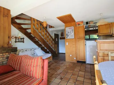a living room with a staircase and a kitchen at Duplex 8 pers avec parking, pied des pistes, proche commodités - FR-1-572-127 in Arâches-la-Frasse