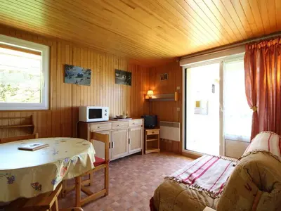 a room with a bed and a table in it at 2 pièces, 4 pers, terrasse, rez-de-jardin, face aux pistes, proche centre, équipements inclus - FR-1-572-160 in Arâches-la-Frasse