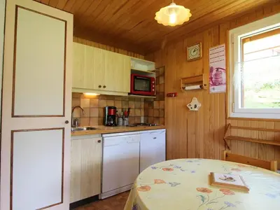 a kitchen with a table and a window and a door at 2 pièces, 4 pers, terrasse, rez-de-jardin, face aux pistes, proche centre, équipements inclus - FR-1-572-160 in Arâches-la-Frasse
