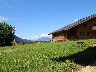 a large grassy field next to a barn at 2 pièces, 4 pers, terrasse, rez-de-jardin, face aux pistes, proche centre, équipements inclus - FR-1-572-160 in Arâches-la-Frasse