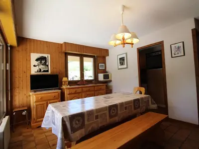 a bedroom with a bed and a tv and a table at Appartement cosy 2 pièces, terrasse, pour 6 personnes au pied des pistes et proche du centre - FR-1-572-125 in Arâches-la-Frasse