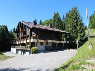 a large building with a porch on a road at Appartement cosy 2 pièces, terrasse, pour 6 personnes au pied des pistes et proche du centre - FR-1-572-125 in Arâches-la-Frasse