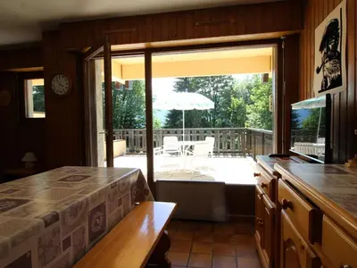 a bedroom with a view of a deck with an open window at Appartement cosy 2 pièces, terrasse, pour 6 personnes au pied des pistes et proche du centre - FR-1-572-125 in Arâches-la-Frasse