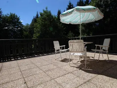 two chairs and a table with an umbrella on a patio at Appartement cosy 2 pièces, terrasse, pour 6 personnes au pied des pistes et proche du centre - FR-1-572-125 in Arâches-la-Frasse