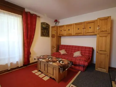 a living room with a red couch and a table at Charmant 2P avec balcon, 5 couchages, pieds des pistes, proche télécabine et centre village - FR-1-572-171 in Arâches-la-Frasse