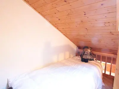 a bedroom with a bed with a backpack on it at Studio mezzanine 5 pers, pied des commerces, 450m des pistes - FR-1-572-184 in Arâches-la-Frasse