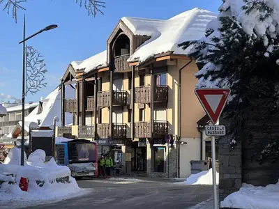 a large building with snow on the top of it at Studio mezzanine 5 pers, pied des commerces, 450m des pistes - FR-1-572-184 in Arâches-la-Frasse