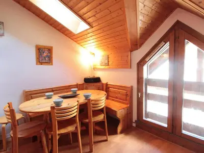 a dining room with a wooden table and chairs at Studio mezzanine 5 pers, pied des commerces, 450m des pistes - FR-1-572-184 in Arâches-la-Frasse