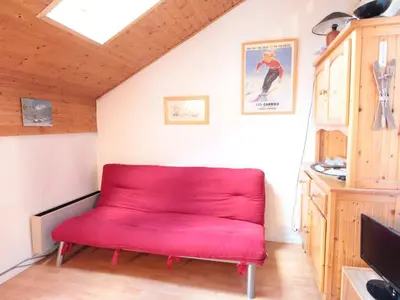 a red couch in the corner of a room at Studio mezzanine 5 pers, pied des commerces, 450m des pistes - FR-1-572-184 in Arâches-la-Frasse