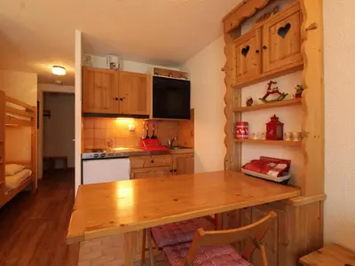 a kitchen with wooden cabinets and a wooden table at Studio rénové 4 pers, centre village, proche pistes et commerces - FR-1-572-61 in Arâches-la-Frasse