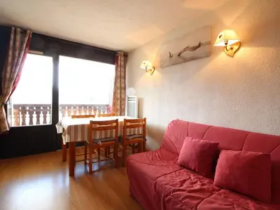 a living room with a red couch and a table at Studio 4 pers. proche pistes et commerces, balcon, parking - FR-1-572-131 in Arâches-la-Frasse