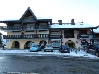 a large building with cars parked in front of it at Studio 4 pers au pied des pistes, balcon, casier à skis, TV - FR-1-572-178 in Arâches-la-Frasse