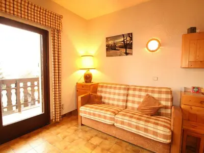 a living room with a couch and a window at Studio 4 pers au pied des pistes, balcon, casier à skis, TV - FR-1-572-178 in Arâches-la-Frasse