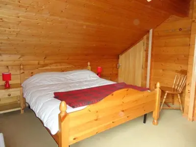 a bedroom with a bed in a log cabin at Chalet 3 Chambres 8 Pers, 800m Pistes, Parking Couvert, Poêle à Bois, Quartier Calme - FR-1-572-224 in Arâches-la-Frasse