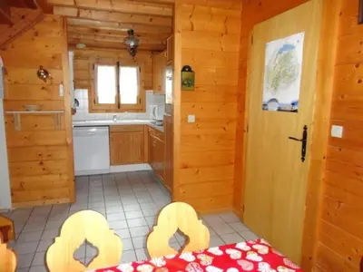 a room with a kitchen with a table and a door at Chalet 3 Chambres 8 Pers, 800m Pistes, Parking Couvert, Poêle à Bois, Quartier Calme - FR-1-572-224 in Arâches-la-Frasse