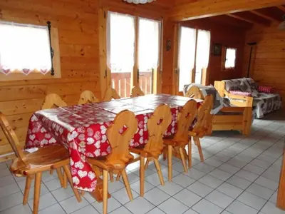 a dining room with a table and wooden chairs at Chalet 3 Chambres 8 Pers, 800m Pistes, Parking Couvert, Poêle à Bois, Quartier Calme - FR-1-572-224 in Arâches-la-Frasse