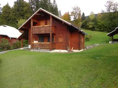 a wooden house with a grassy yard in front of it at Chalet 3 Chambres 8 Pers, 800m Pistes, Parking Couvert, Poêle à Bois, Quartier Calme - FR-1-572-224 in Arâches-la-Frasse