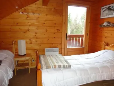 a bedroom with two beds in a log cabin at Chalet 3 Chambres 8 Pers, 800m Pistes, Parking Couvert, Poêle à Bois, Quartier Calme - FR-1-572-224 in Arâches-la-Frasse