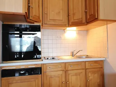 a kitchen with wooden cabinets and a sink at Appartement cosy 6 pers, balcon plein sud - à 550m du centre et à 1000m des pistes - FR-1-572-198 in Arâches-la-Frasse