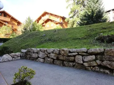 a stone retaining wall in front of a house at Studio rénové pour 4 personnes, centre station, proche pistes et commodités - FR-1-572-24 in Arâches-la-Frasse